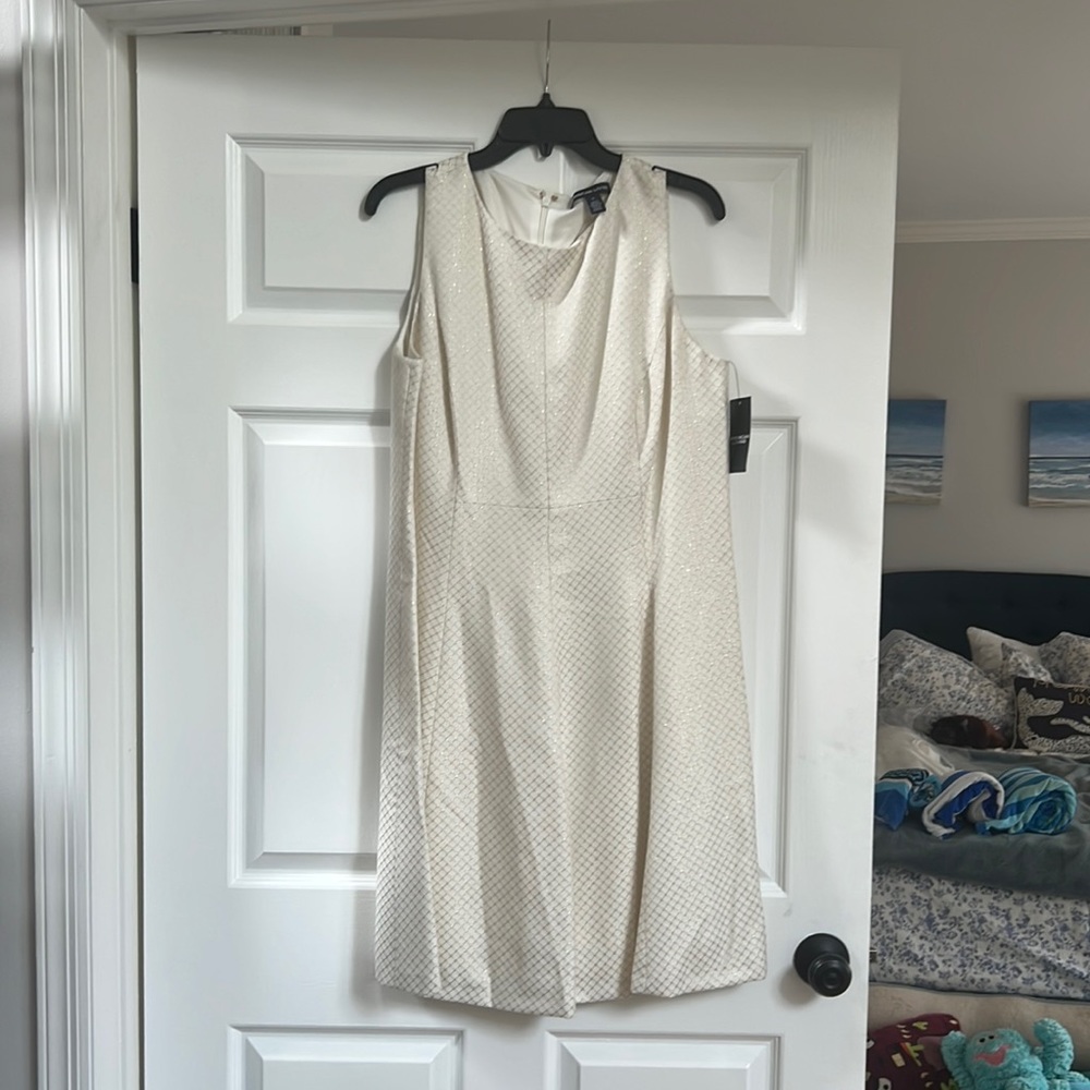 White sleeveless dress with gold pattern detail and flattering A line skirt.